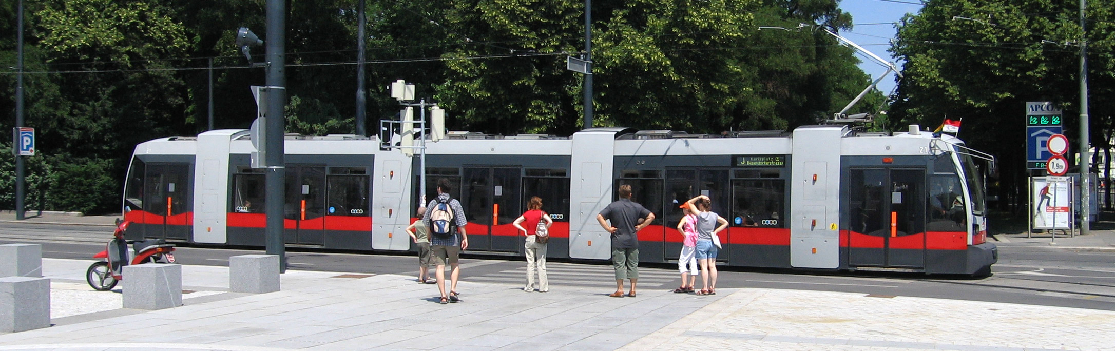 Straßenbahn und wartende Menschen an einer Haltestelle in Wien